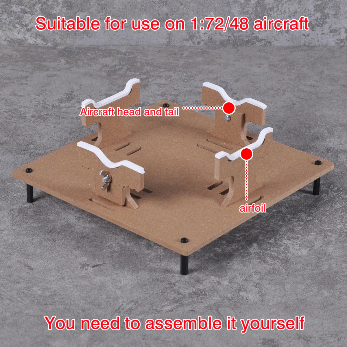 Adjustable brown cardboard aircraft model painting stand with white plastic airfoil supports for precision hobby tools