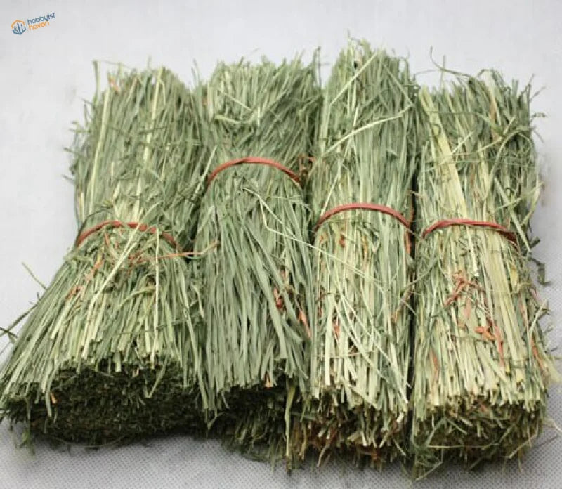Four straw huts: neatly bundled light green hay packages tied with reddish-brown twine