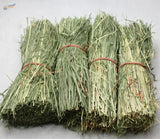 Four straw huts: neatly bundled light green hay packages tied with reddish-brown twine