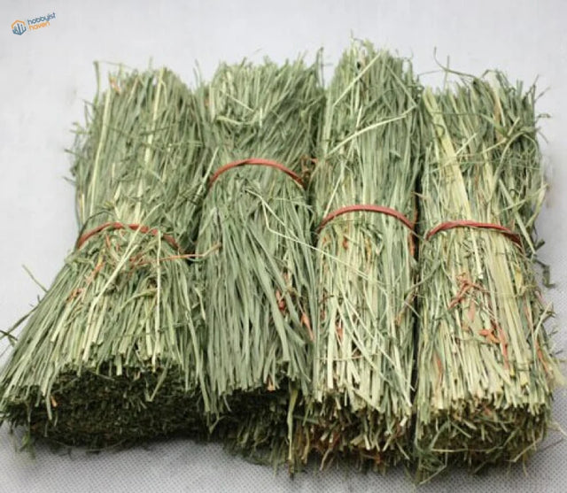 Four straw huts: neatly bundled light green hay packages tied with reddish-brown twine