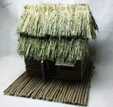 Rustic miniature thatched hut crafted from natural wood and dried grass.