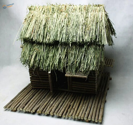 Rustic miniature thatched hut crafted from natural wood and dried grass.