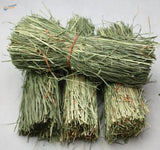 Bundles of dried green hay tied with reddish-brown twine in Four Straw Huts
