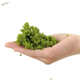 A mound of vibrant green, textured kinetic sand held in an open palm.