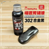 A sleek glossy black metallic paint bottle with silver cap and red white label hobby mio 50ml oil-based for scale modeling tools