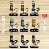 Six bottles of hobby mio 50ml oil-based metallic paints in gold silver black with sample swatches for precision hobby tools