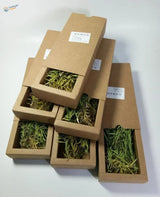 Long leaf shrubs in brown boxes with green yellow dried grass