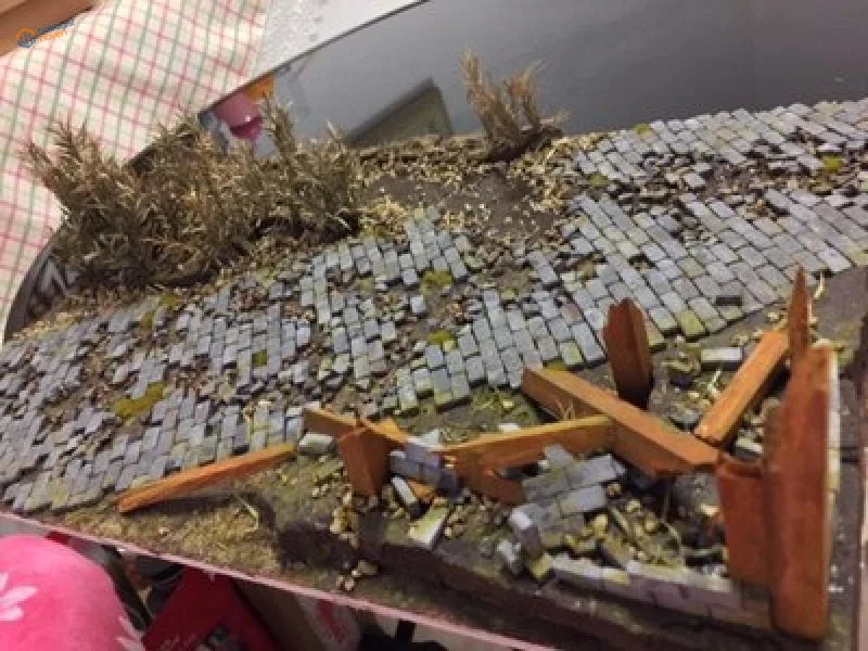 Detailed miniature diorama of ruined street with long leaf shrubs