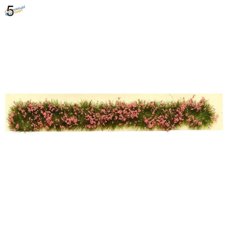 Miniature flower clusters in pink on artificial grass strip