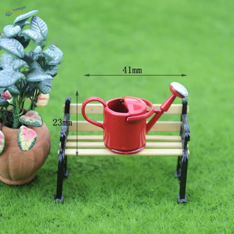 Red miniature watering can with silver spout on bench for miniature flowers dioramas