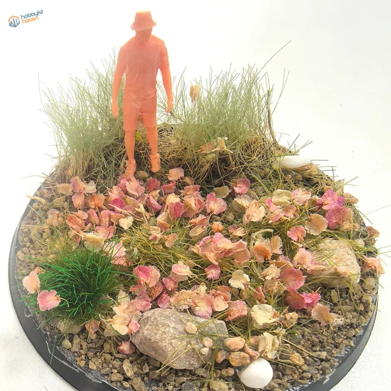 Orange plastic figurine in miniature pink leaves diorama