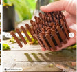 A compact brown miniature wooden picket fence made of interlocking wooden pickets for garden and diorama decoration