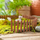 Miniature wooden picket fence in terracotta with thin slats and wire bindings for garden and diorama decoration