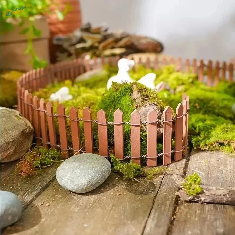 Miniature wooden picket fence with reddish-brown finish featuring thin vertical slats and wire fencing for garden decor