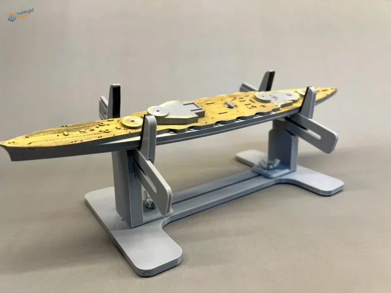Detailed gold and gray model ship on silver model ship holder stand