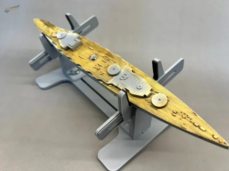 Golden and silver model ship on gray model ship holder stand