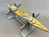 Golden and silver model ship on gray model ship holder stand