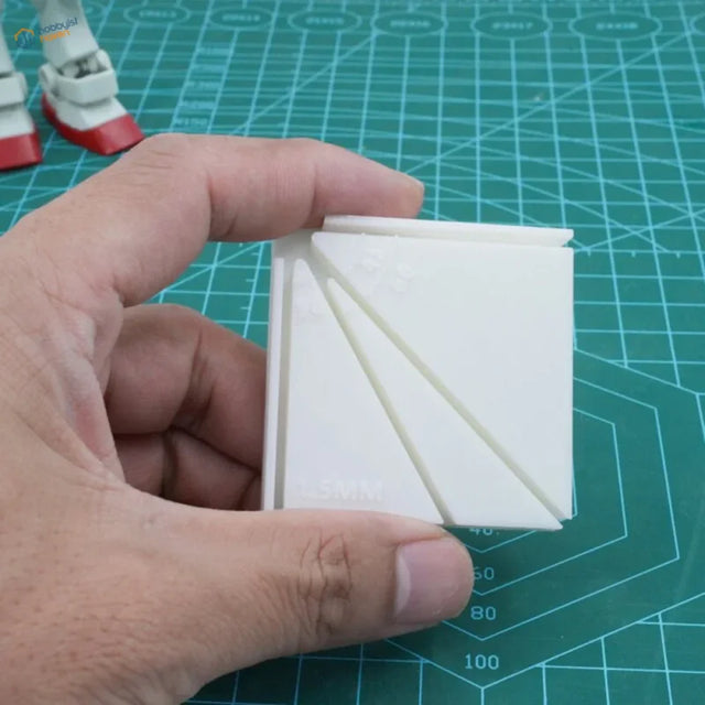 White plastic multi-angle gluing jig with triangular cutouts and layered design for scale modeling tools and model building tools