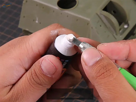 Multi-purpose acrylic putty in black tube with white cap applied by green tool