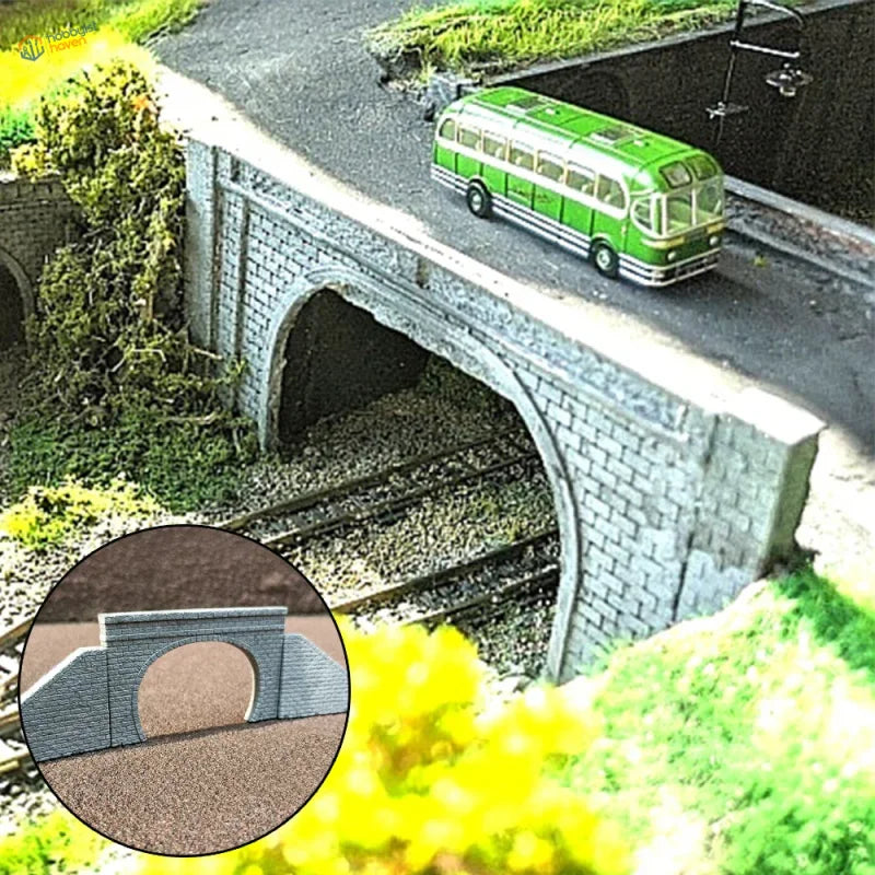 Green and white model bus on a n scale stone tunnel portal with arch opening for model railway scenery