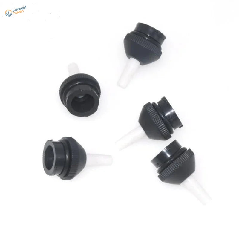 Black plastic bottle caps with white tapered spouts on powerful desoldering pump