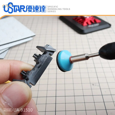 Gray plastic model kit sanded with pre-cut sandpaper discs on rotary tool