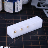 Precision center punching block with white plastic mold and 3 gold studs