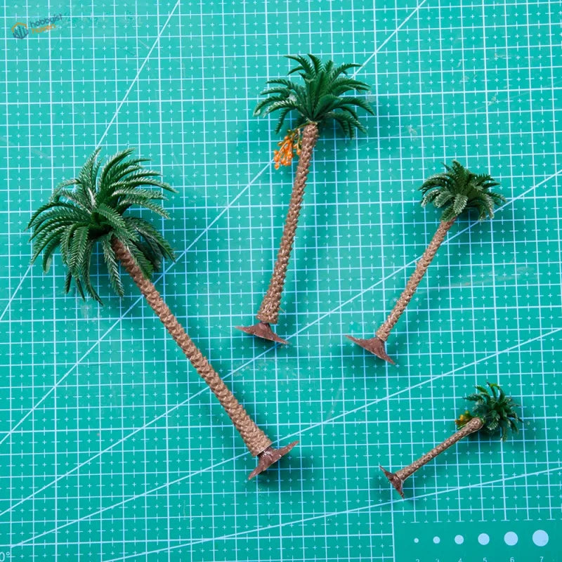 Four scale model palm trees with green fronds and metal bases