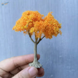 Vibrant orange moss-like scale model tree with gray trunk
