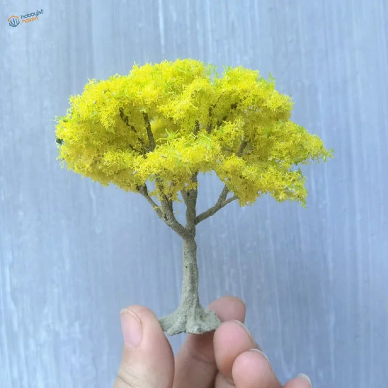 Vibrant yellow moss-like foliage on scale model tree with gray trunk
