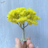 Vibrant yellow moss-like foliage on scale model tree with gray trunk