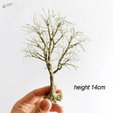 Hand holding 14cm scale model tree with twisted green textured branches