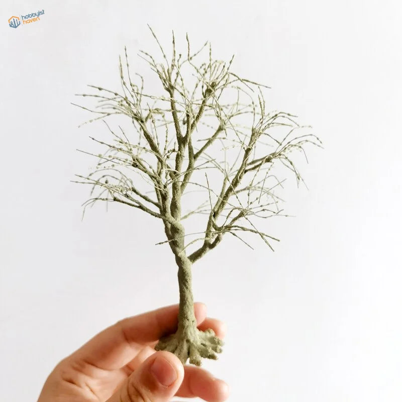 Delicate handcrafted scale model tree with textured greenish-gray trunk