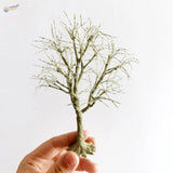 Delicate handcrafted scale model tree with textured greenish-gray trunk