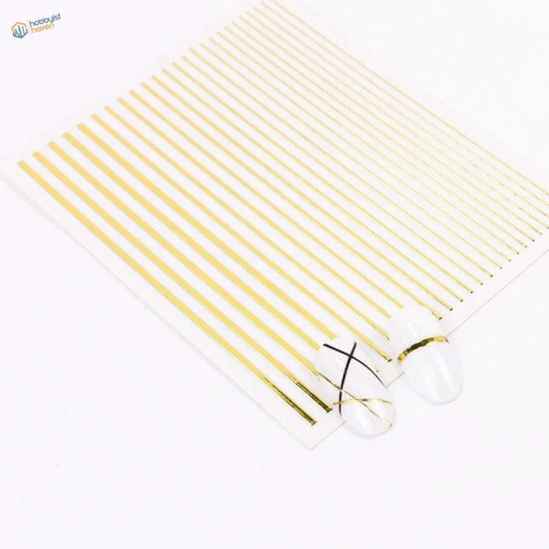 Gold foil stripe stickers on white nails with black cross designs