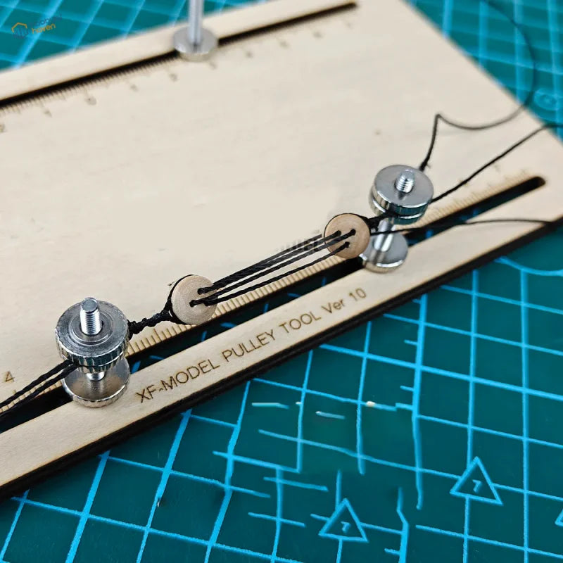 Wooden xf-model ship model pulley block fixator tool with silver metal pulleys and threaded rods for precise string control