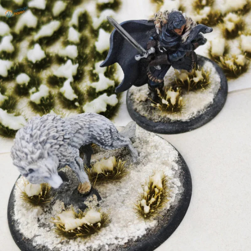 Detailed grey wolf miniature on snowy grass patches base