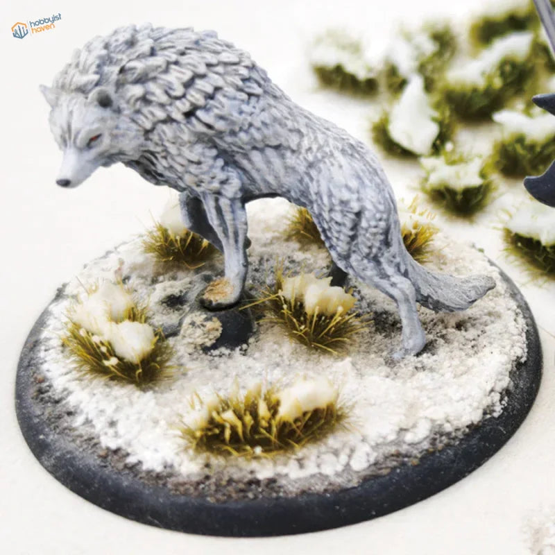 Detailed gray-furred wolf miniature on snowy grass patches base