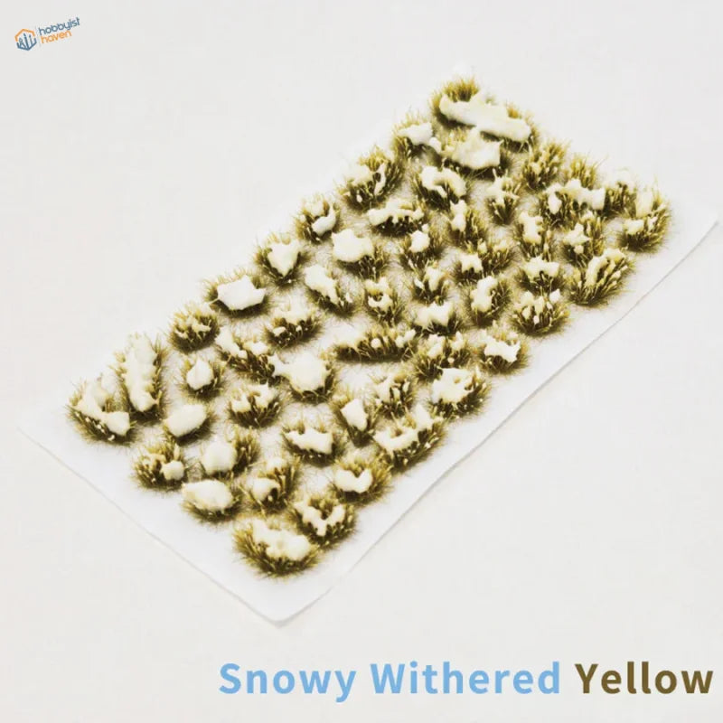 Snowy grass patches with snow-dusted withered yellow tufts in grid on white sheet