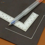 A compact stainless steel mini try square with a transparent blue ink pen resting diagonally across the ruler