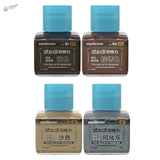 Four square glass bottles of stedicolor modeling stains with bright blue caps labeled in chinese for stedi weathering wash on scale models