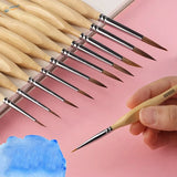 Hand holding triangular handle precision brush with light wood handle