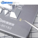 Gold grid-patterned microchip held by tweezers in UStar photoetch bending tool