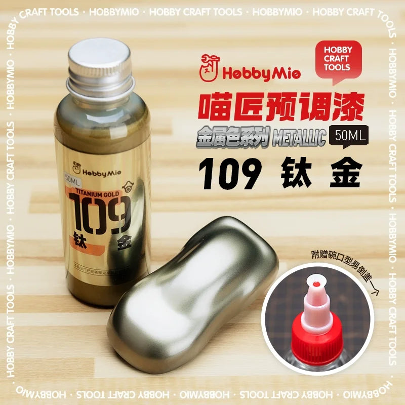 A sleek metallic gold 50ml bottle of Hobby Mio oil-based paint ideal for scale modeling and precision hobby tools