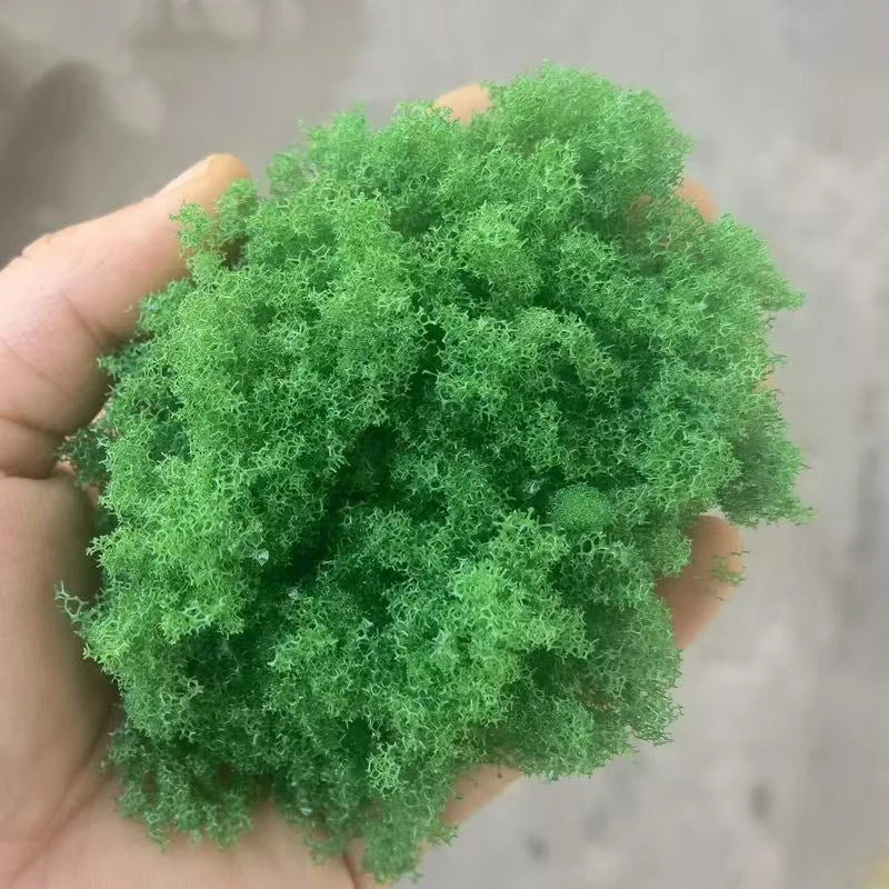 Hand holding 22g Green Tree Powder, vibrant green fluffy moss for scale modeling tools