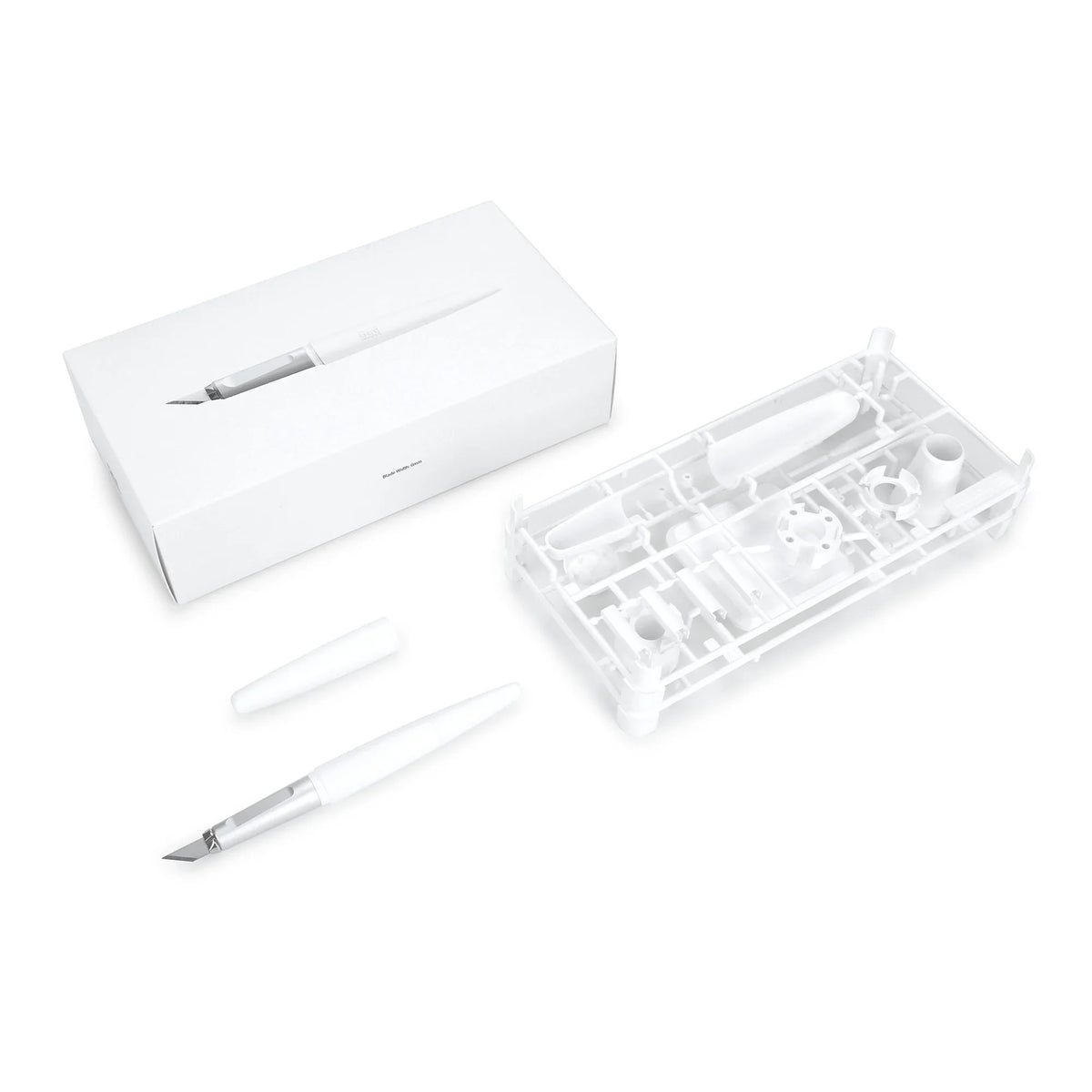 White plastic pen knife with metallic blade and cap in minimalist packaging for precision scale modeling tools and replacement blades