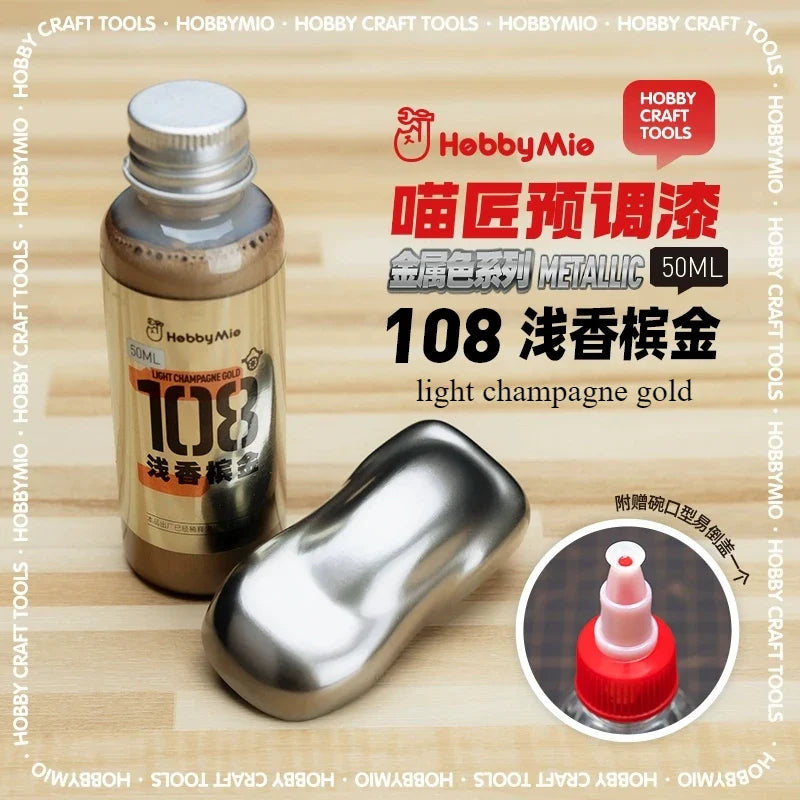A 50ml bottle of hobby mio metallic light champagne gold oil-based paint with silver cap for scale modeling tools