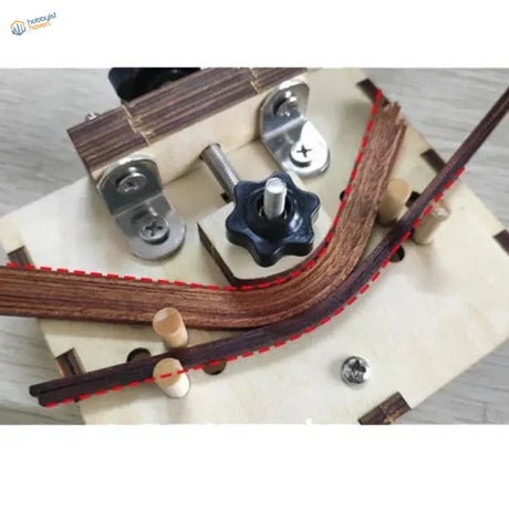 Brown leather strap with red stitching on wood bending tool